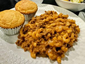 Elbow macaroni with hamburger and creamy tomato sauce with cornbread